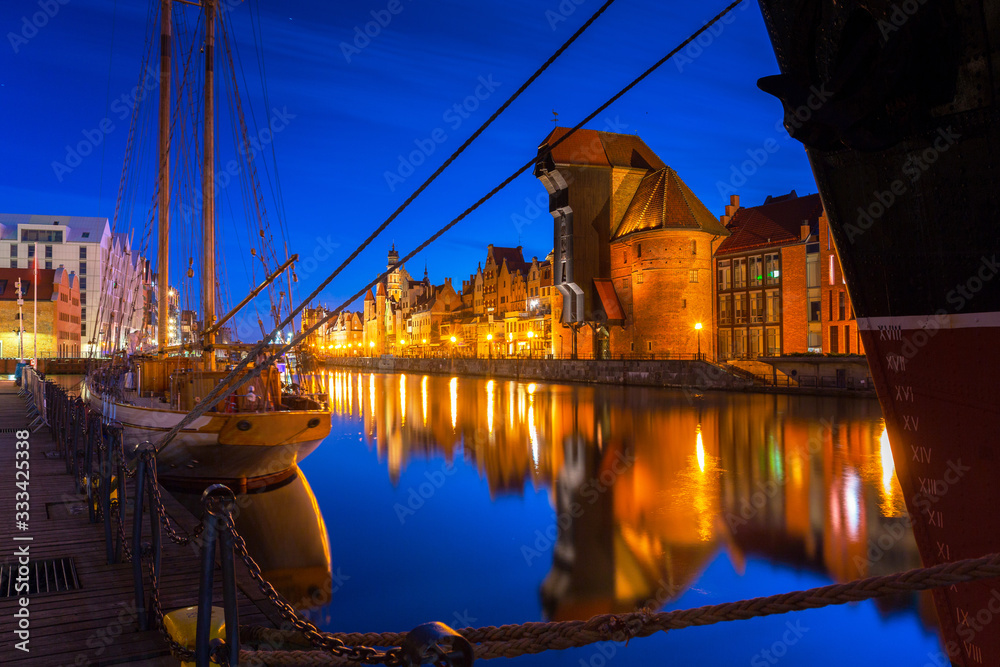 Old town in Gdansk with historical port crane over Motlawa river at night, Poland.