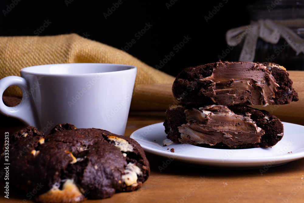 Delicious cookie cakes with chocolate with a cup of coffee on a wooden board with copy space