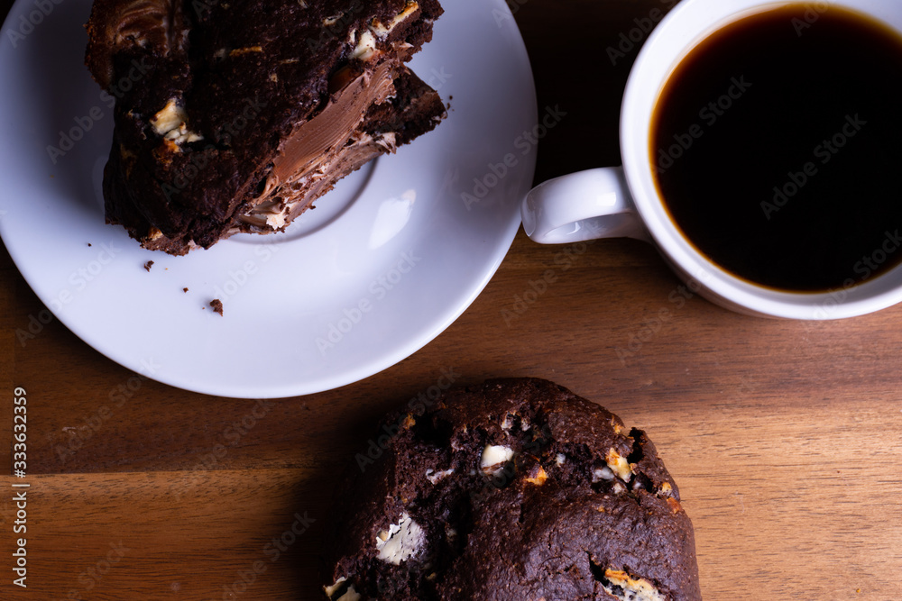 Delicious cookie cakes with chocolate with a cup of coffee on a wooden board with copy space