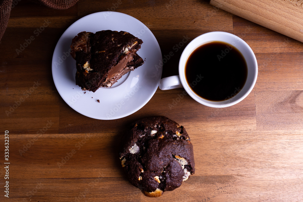 Delicious cookie cakes with chocolate with a cup of coffee on a wooden board with copy space