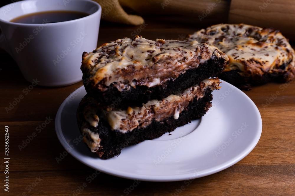 Delicious cookie cakes with chocolate and cheesecake with a cup of coffee on a wooden board with cop