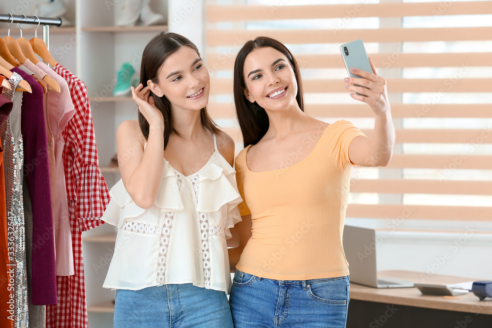 Young women taking selfie in clothes store