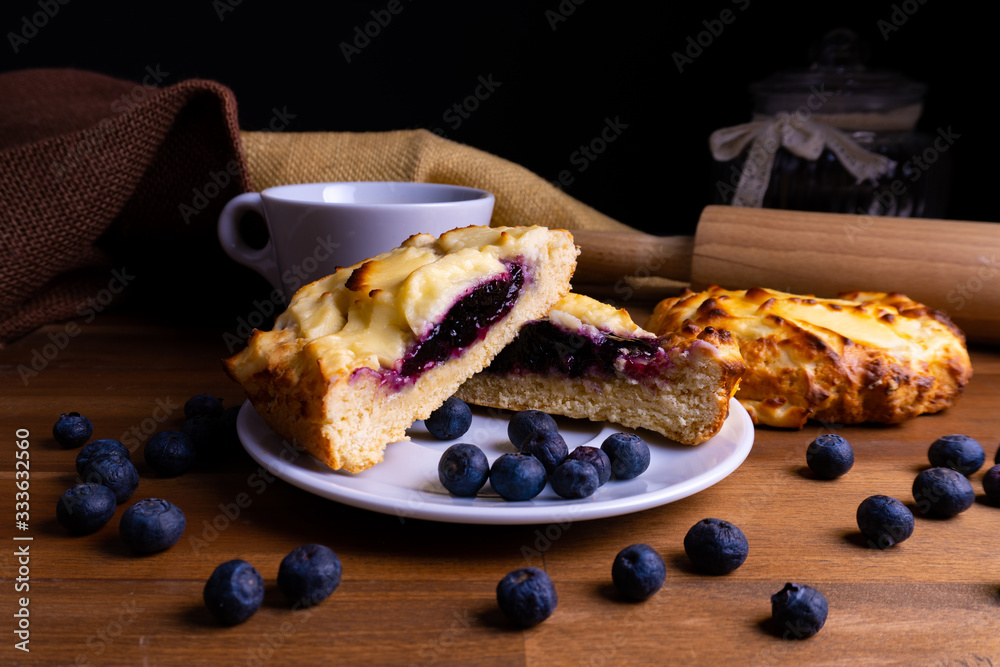 Delicious cheesecake cookie cakes with blueberries and a cup of coffee on a wooden board with copy s