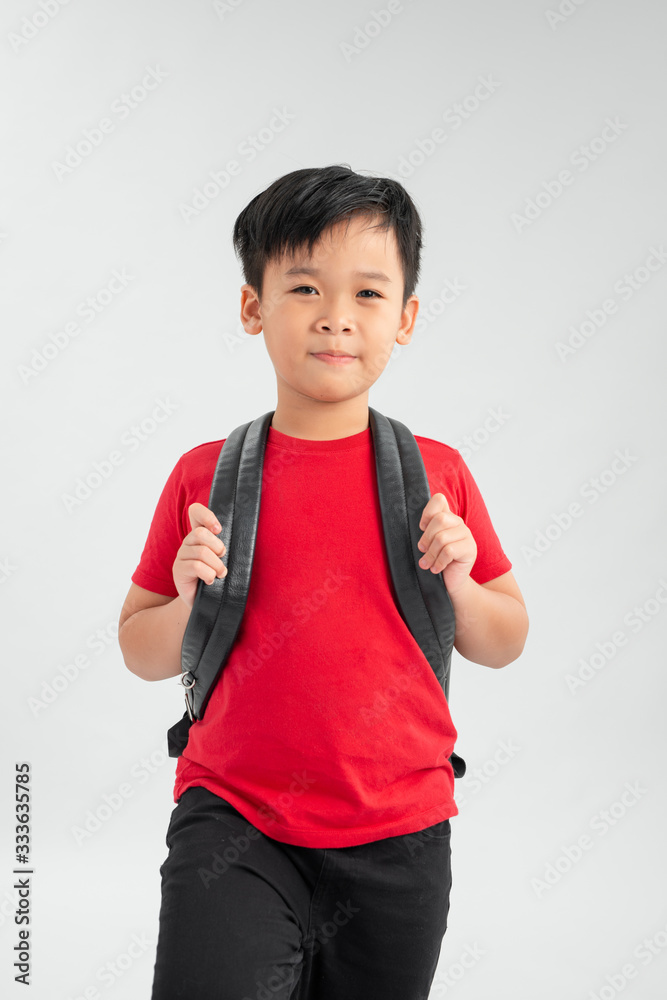 portrait of a school boy with backpack isolated against white background