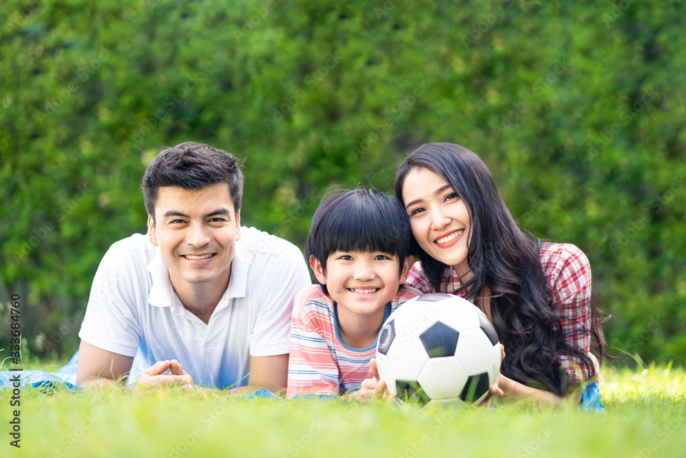 Asian lovely young family are in garden. They lay down on grass and smile with happiness moment. Mot