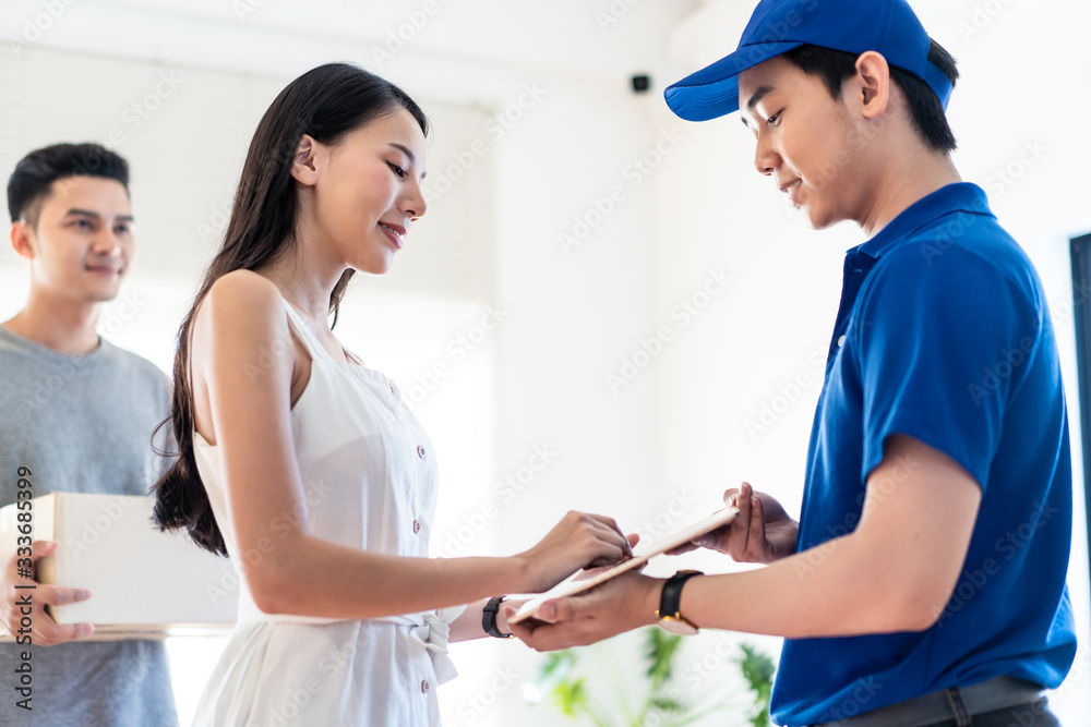 Asian postman delivered object package to young couple at home. People happy to get parcel post very