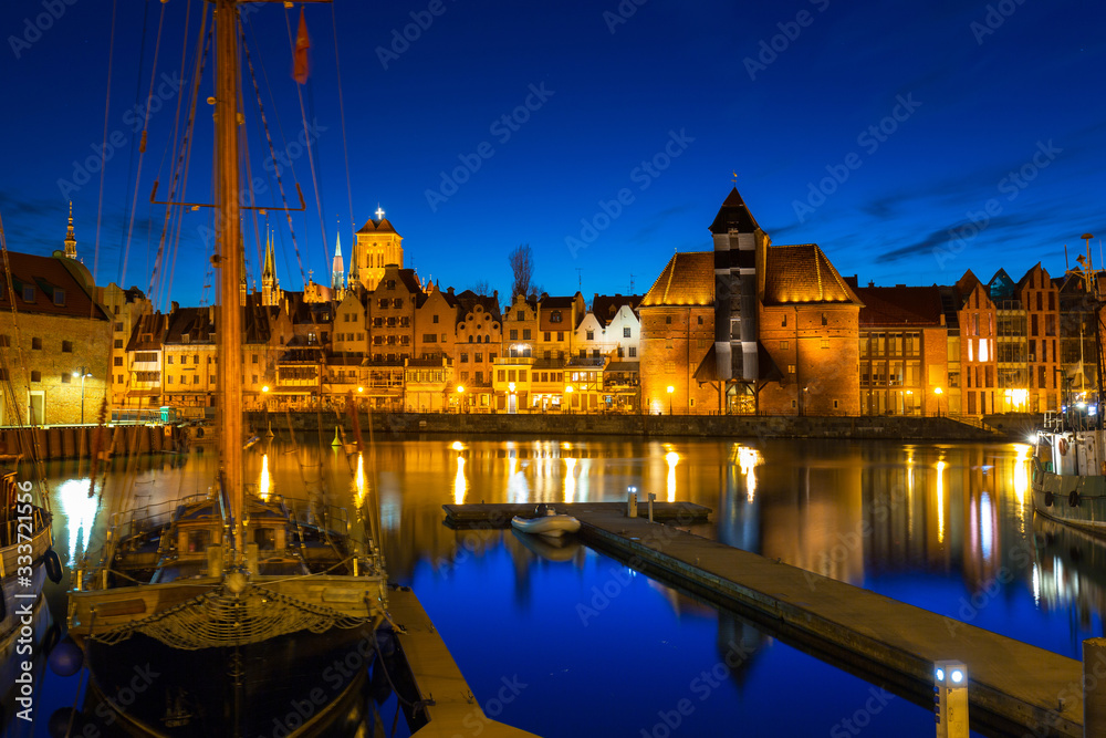 Old town in Gdansk with historical port crane over Motlawa river at night, Poland.