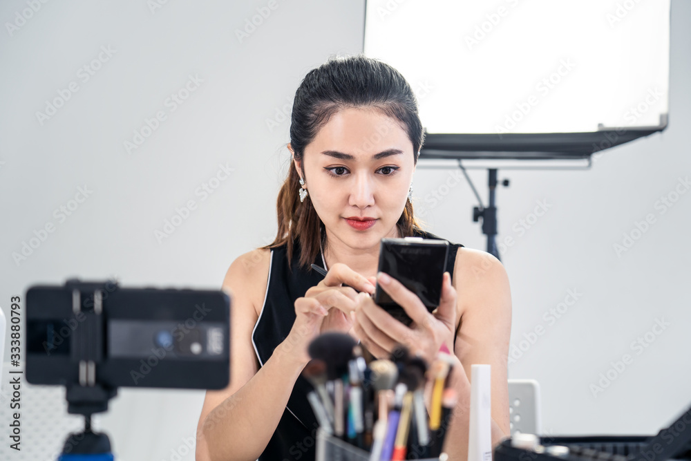 Asian young beauty cosmetic blogger woman use tablet for prepare information before record clip vide