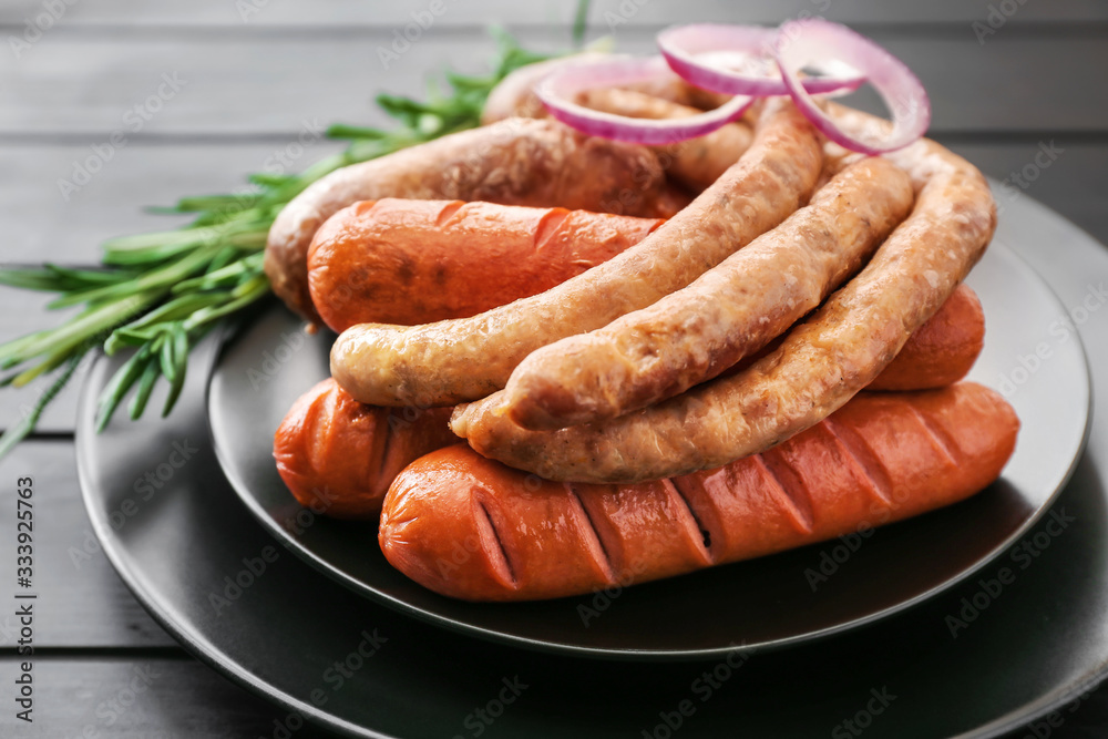 Plate with tasty grilled sausages on table