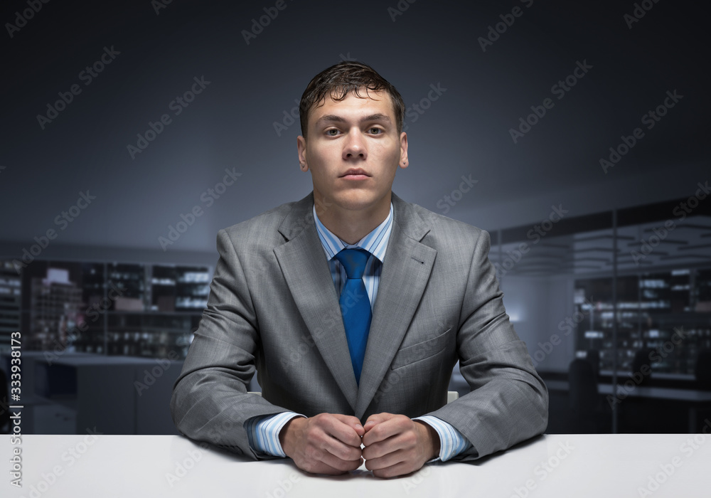 Young man folded hands and having serious face