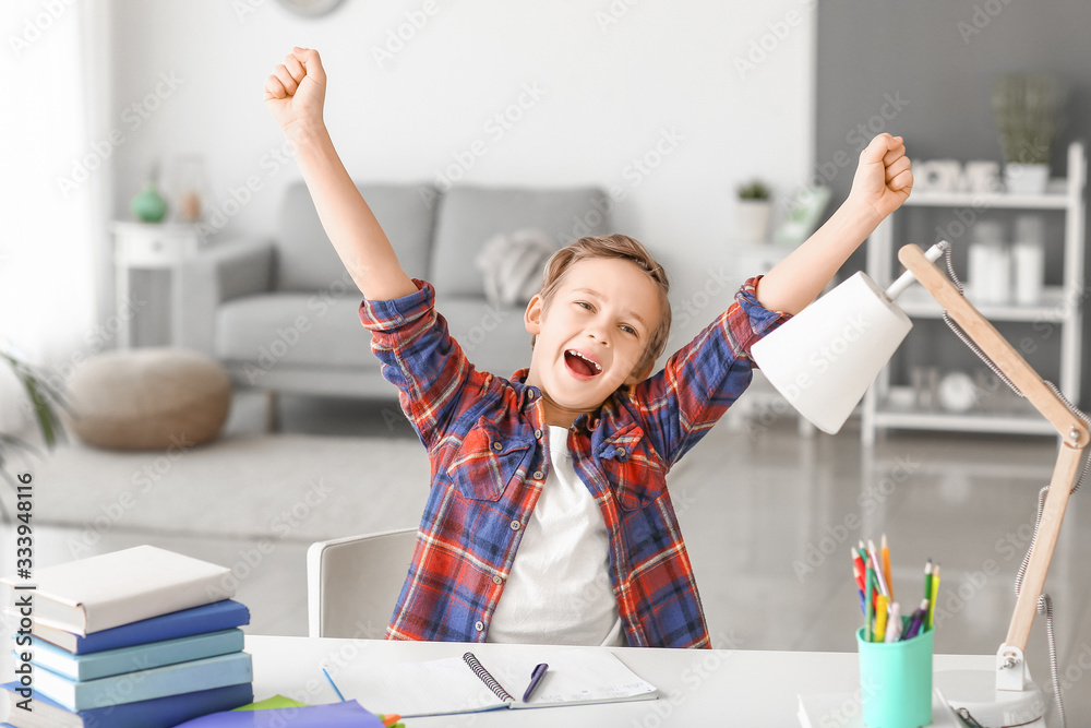 Happy little boy with his homework done at table