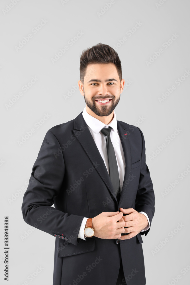 Handsome businessman with healthy hair on light background