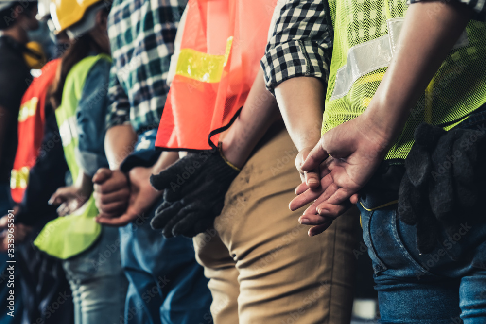 Factory workers standing in a row showing teamwork and unity. Labor and job concept.