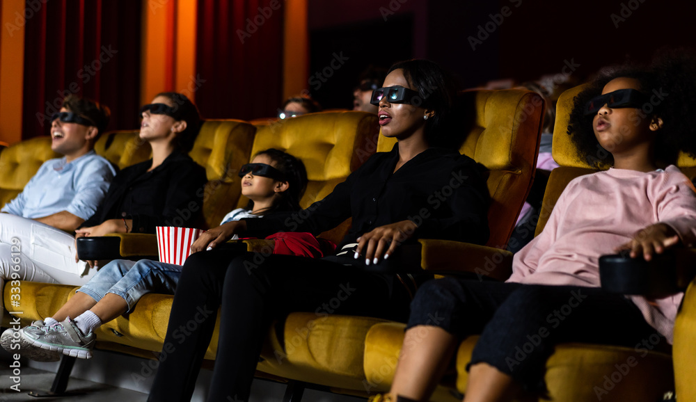 Group of people watch movie with 3D glasses in cinema theater with interest looking at the screen, e