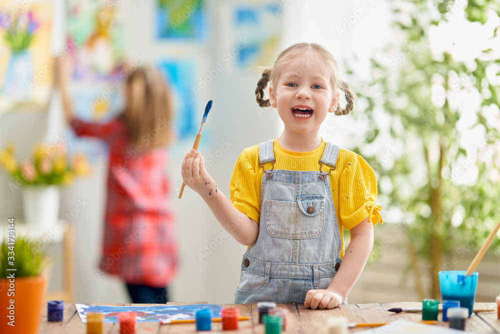 Happy kid is painting at home.