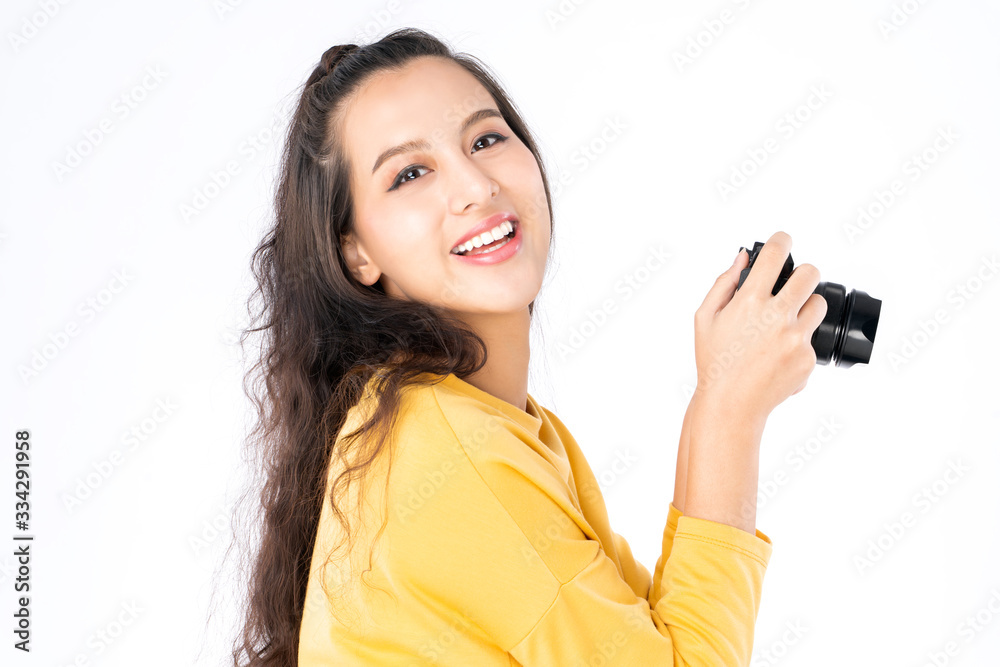 Young beauty Asian woman using camera to take photo and she wearing a yellow sweater shot isolated o