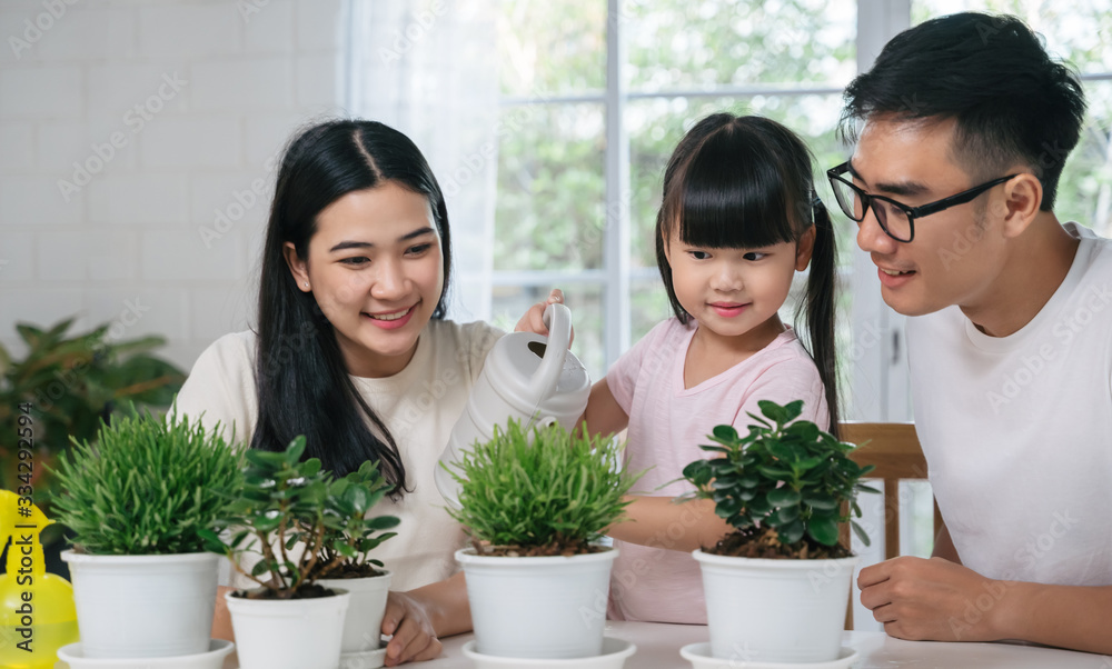 Asian family watering the plants flowers for home gardening concept