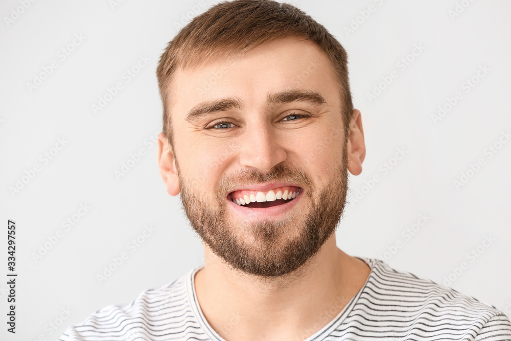 Smiling young man on light background