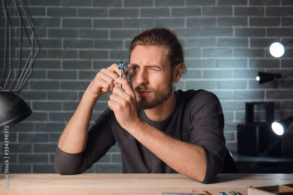 Jeweler examining gemstone in workshop