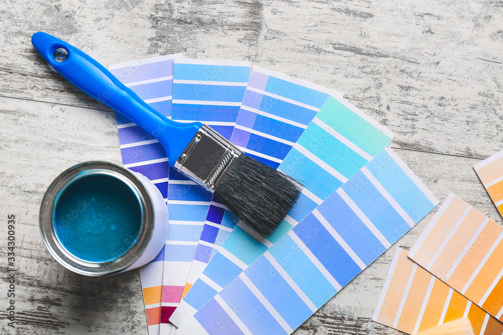 Color swatches with paint and brush on wooden table