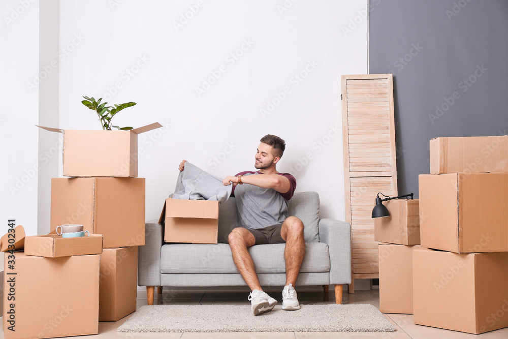 Young man with received new clothes at home