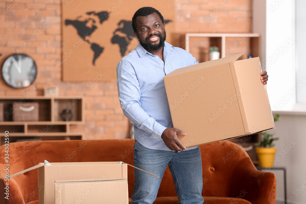 African-American man with moving boxes in his new home