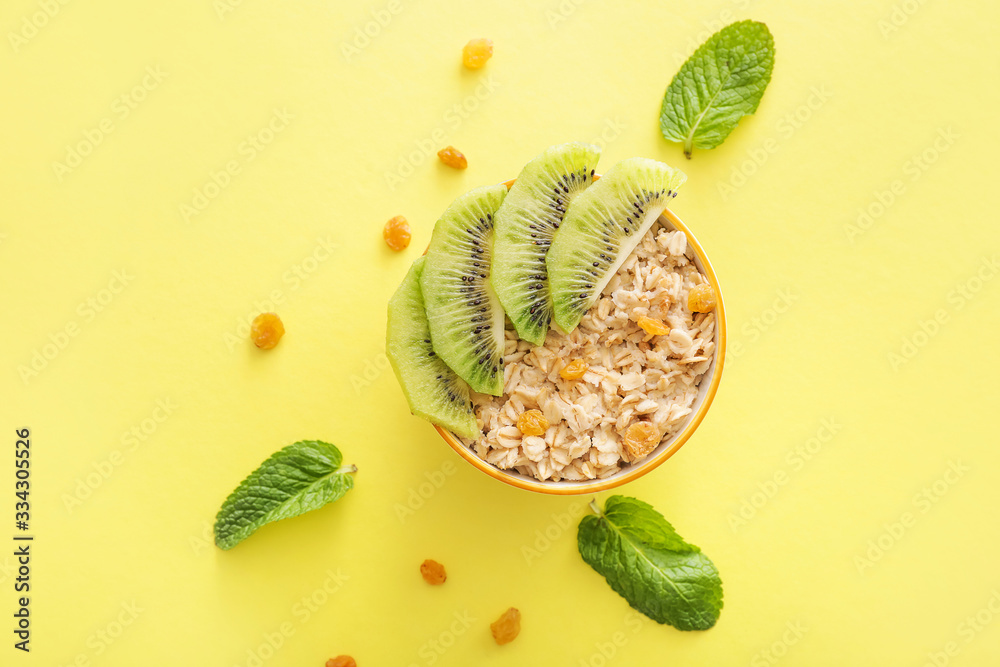 Bowl with tasty sweet oatmeal on color background