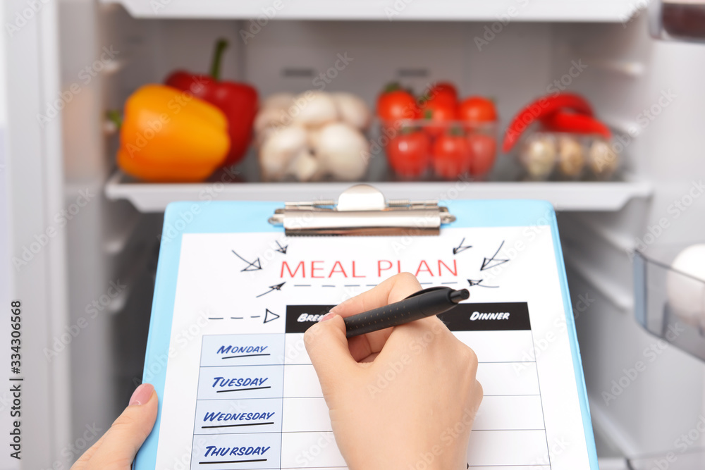 Woman making meal plan in kitchen