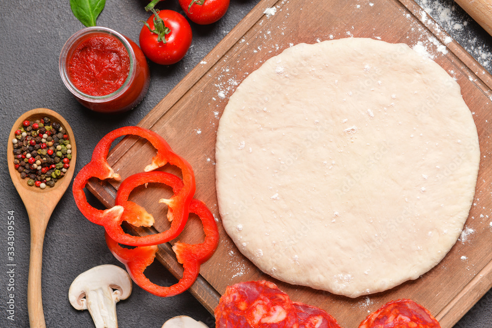 Ingredients for tasty pizza on dark background