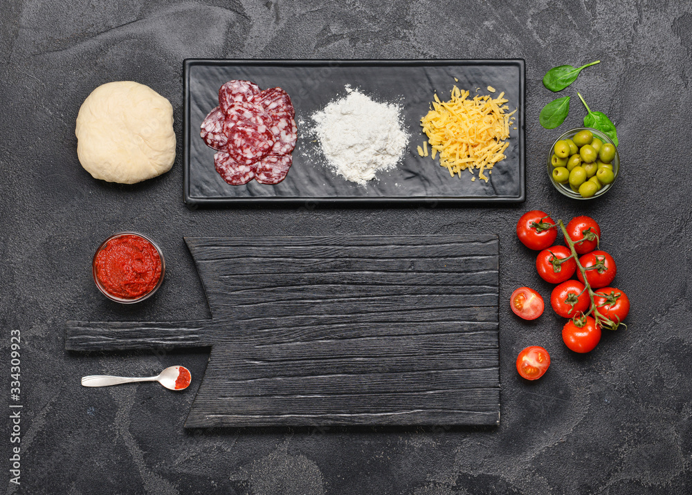 Ingredients for tasty pizza on dark background