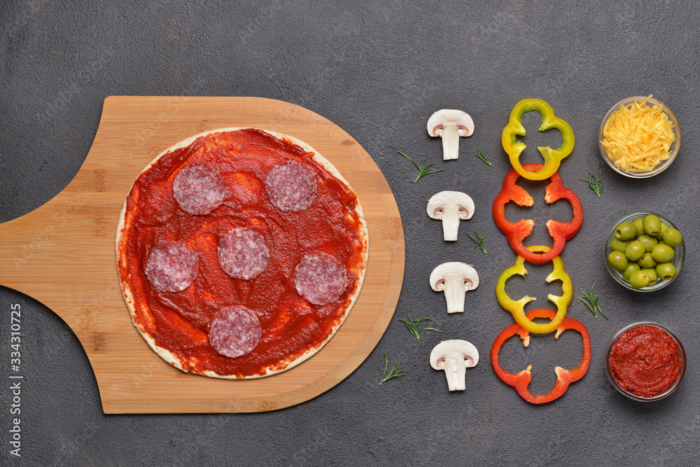 Ingredients for tasty pizza on dark background