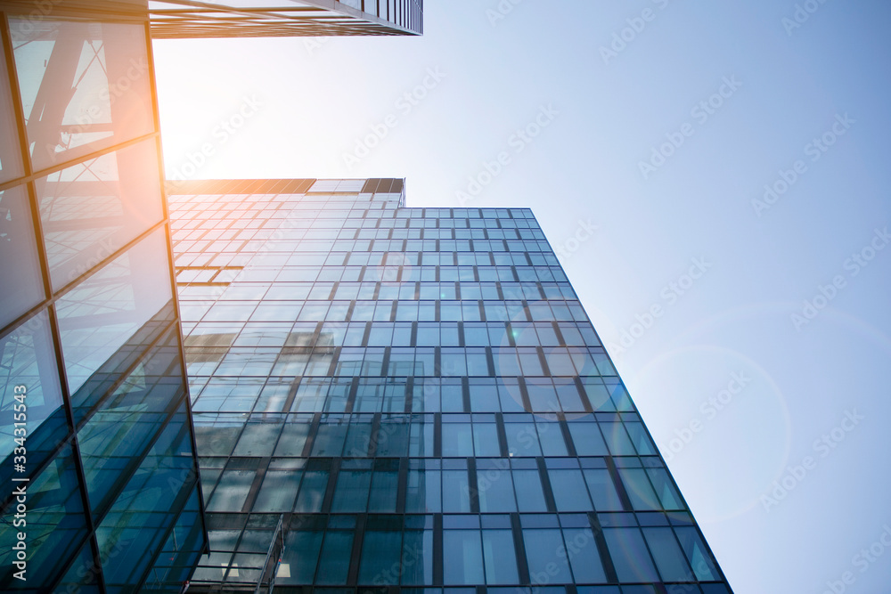 Skyscraper, modern building in the city with sunlight. Glass wall of an office building in the sunli