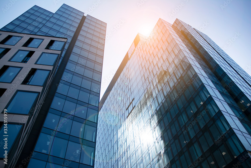 Skyscraper, modern building in the city with sunlight. Glass wall of an office building in the sunli