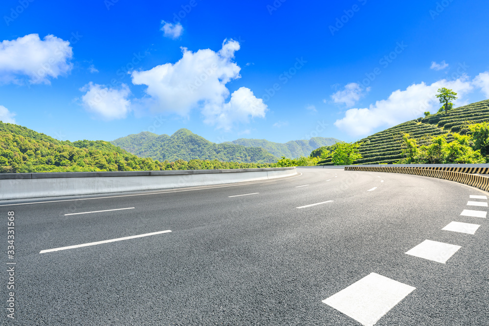 Empty asphalt road and green tea plantation nature landscape.