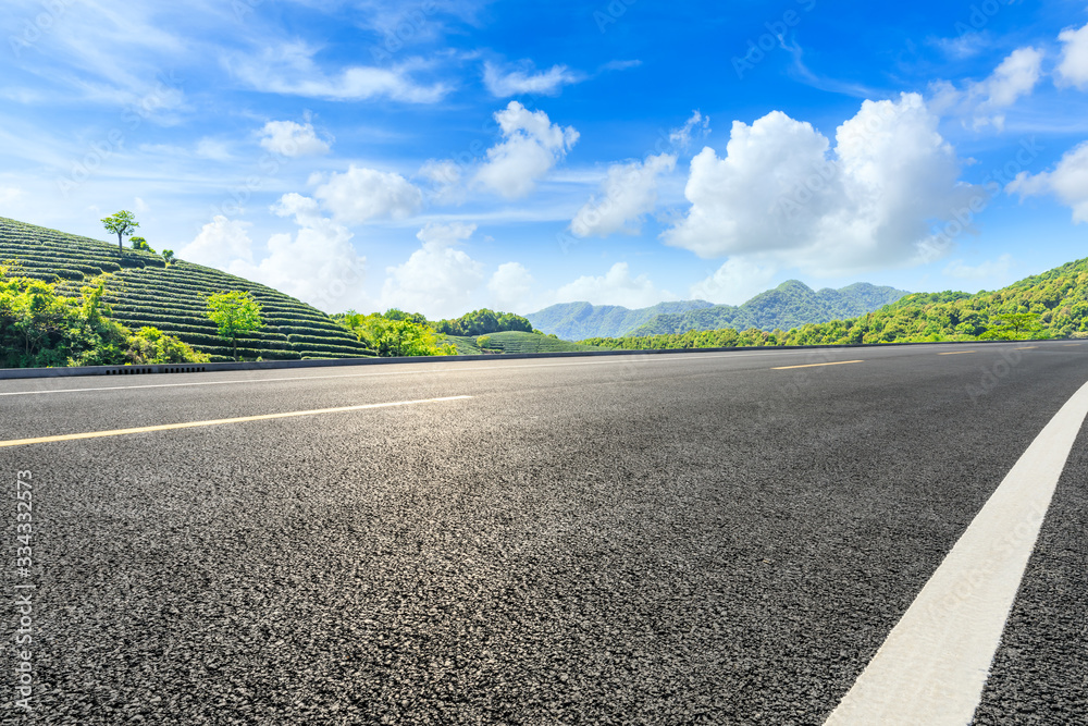 Empty asphalt road and green tea plantation nature landscape.