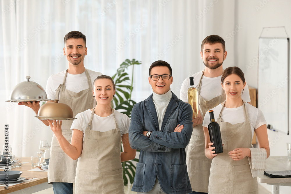 Portrait of teacher and young people attending professional waiter courses