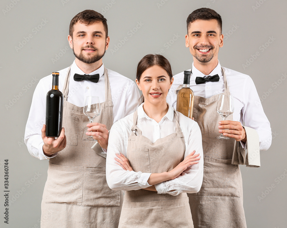 Portrait of waiters on grey background