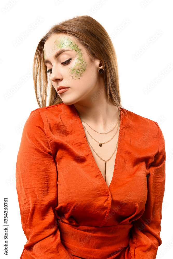 Fashionable young woman with glitters on her body against white background