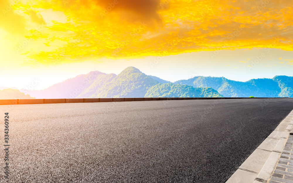 Empty asphalt road and green tea plantation nature landscape at sunset.