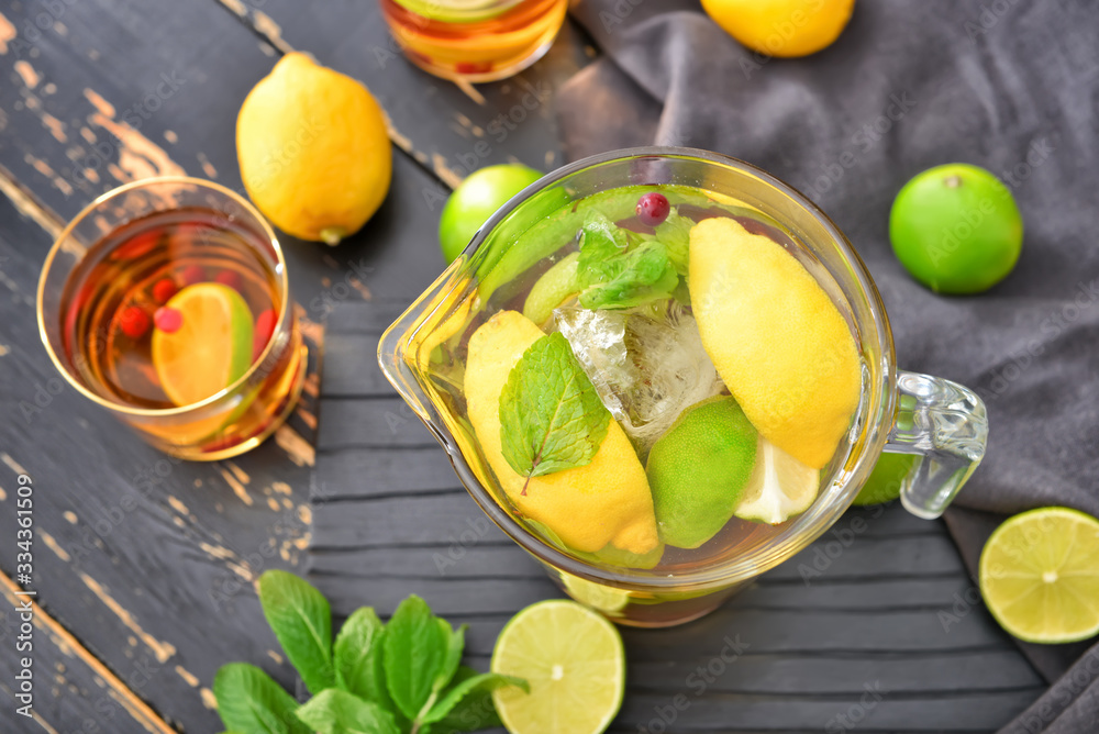 Jug of tasty cold tea on wooden table