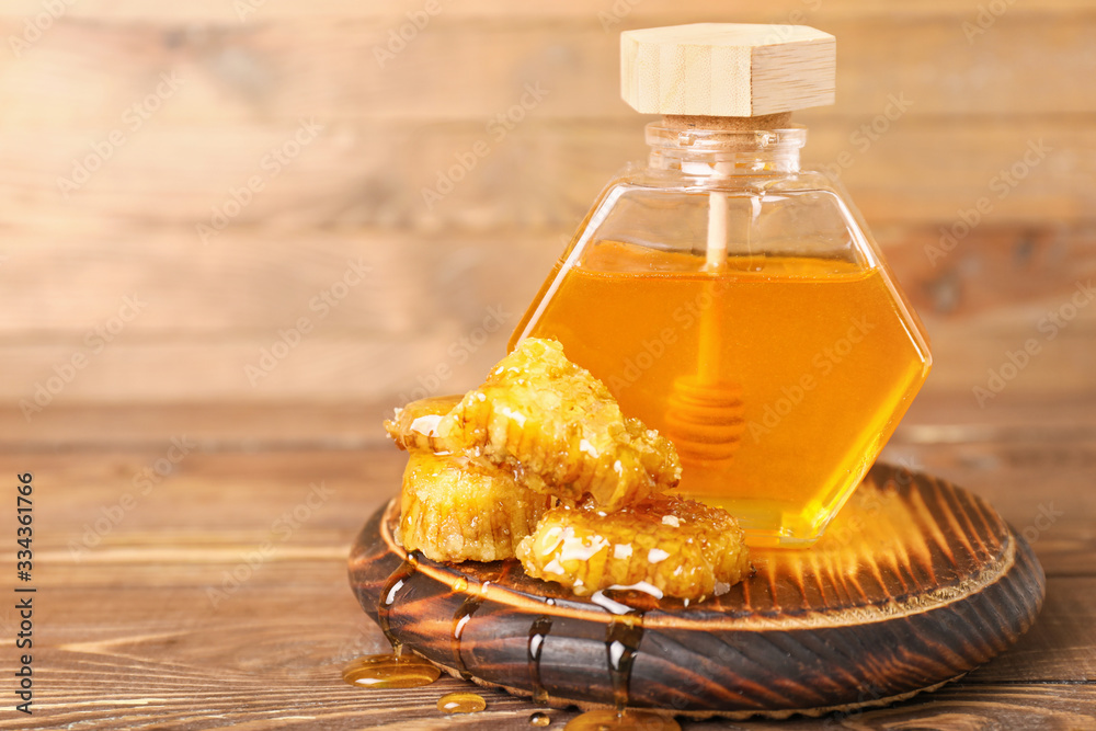 Jar of sweet honey on wooden background