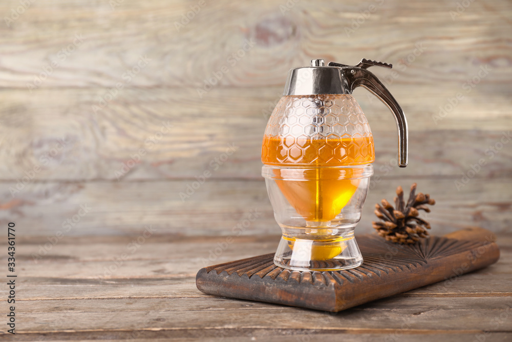 Pot of sweet honey on wooden background