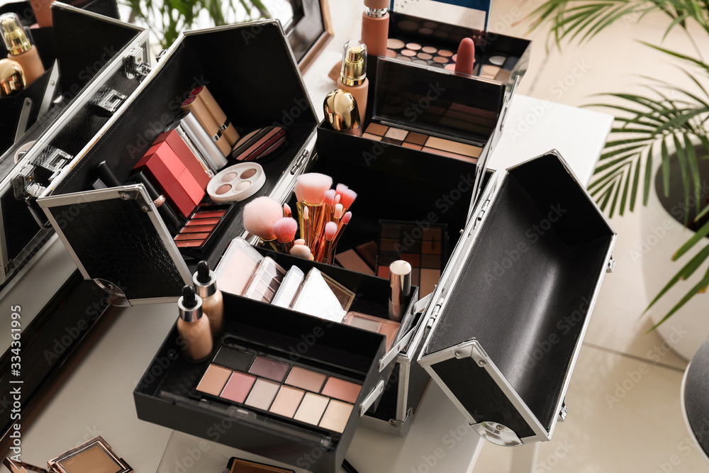 Case of professional makeup artist with decorative cosmetics on table