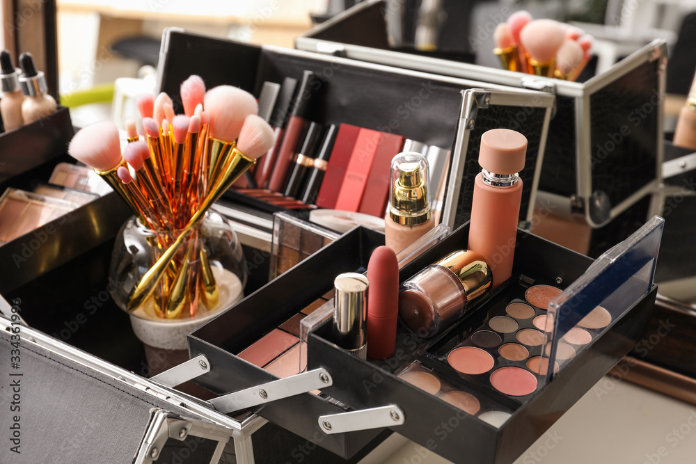 Case of professional makeup artist with decorative cosmetics on table