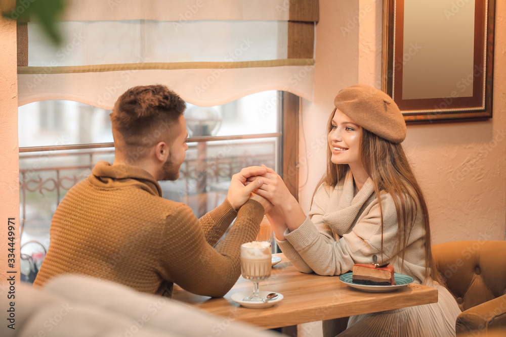 Happy young couple on romantic date in cafe