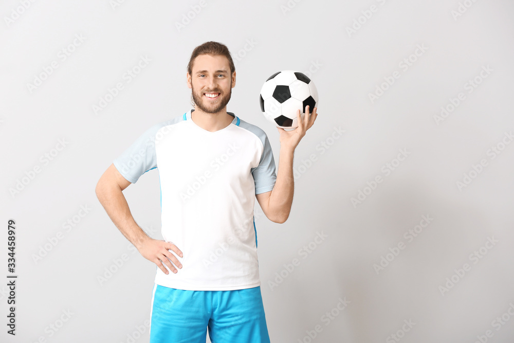 Male football player on grey background