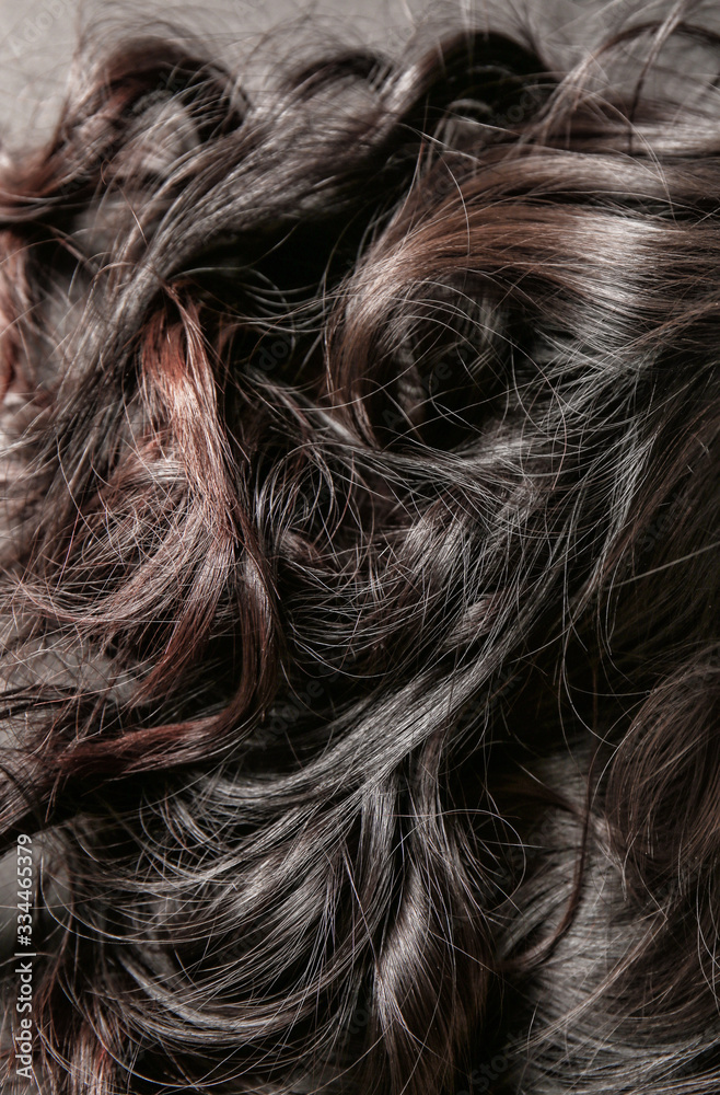 Curly female hair on dark background, closeup