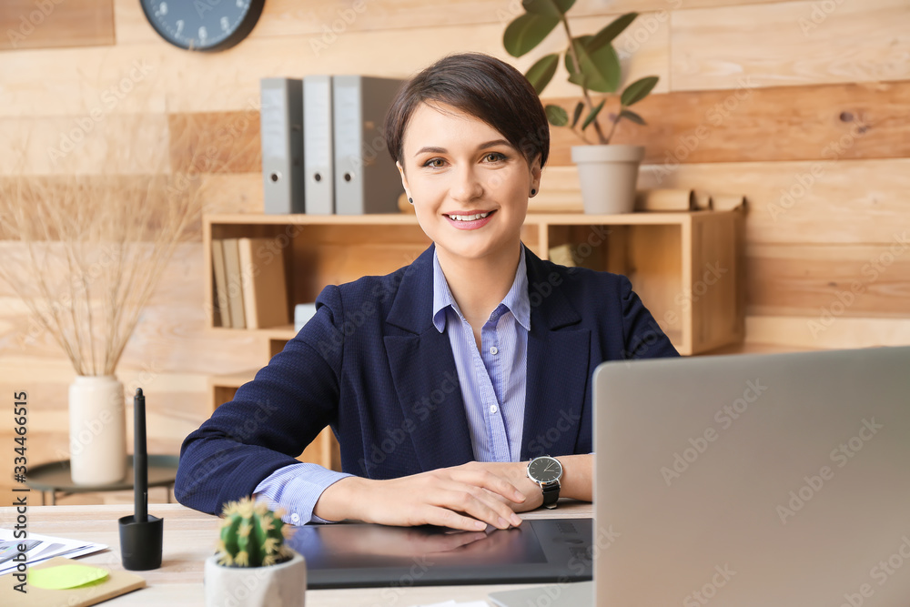 Portrait of young female designer in office