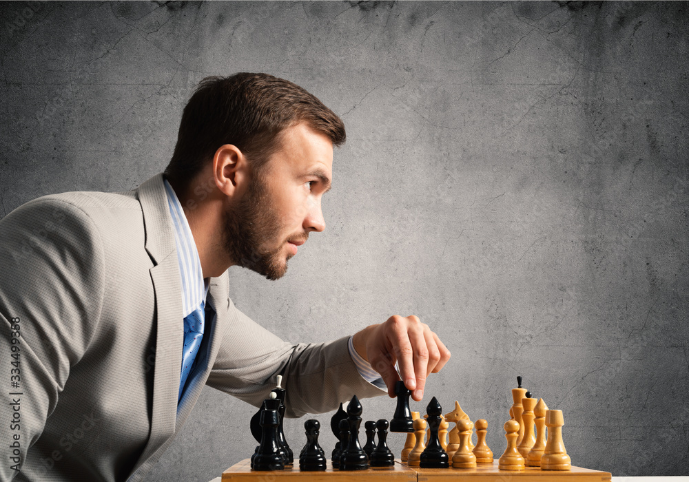 Concentrated businessman playing chess game