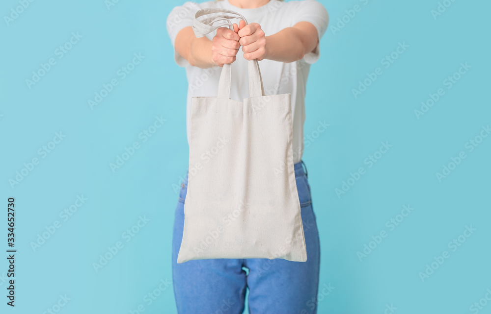 Woman with eco bag on color background